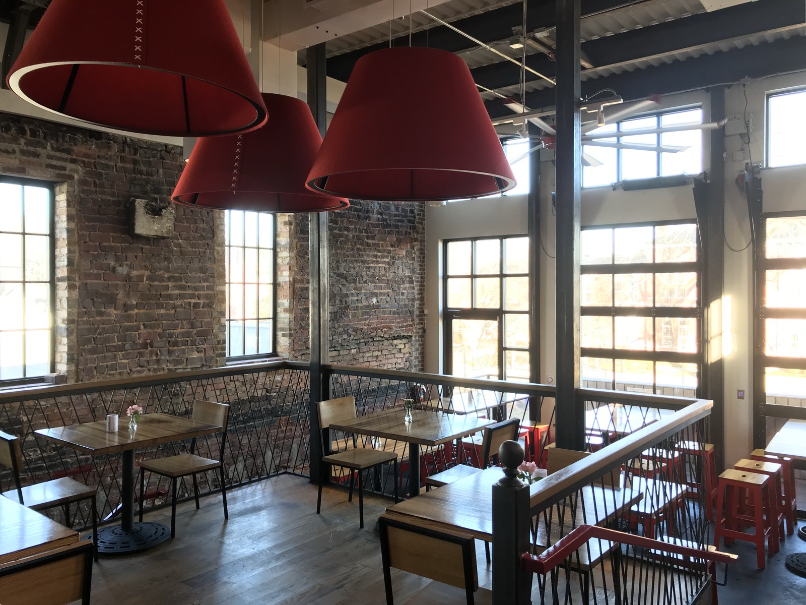 Upstairs dining room with red drum lampshades and tall windows